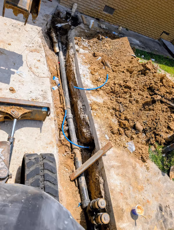 Excavated trench with old and new water service lines