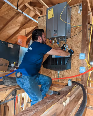 Diamond State Plumbing crew member adjusting water heater connections with wrench
